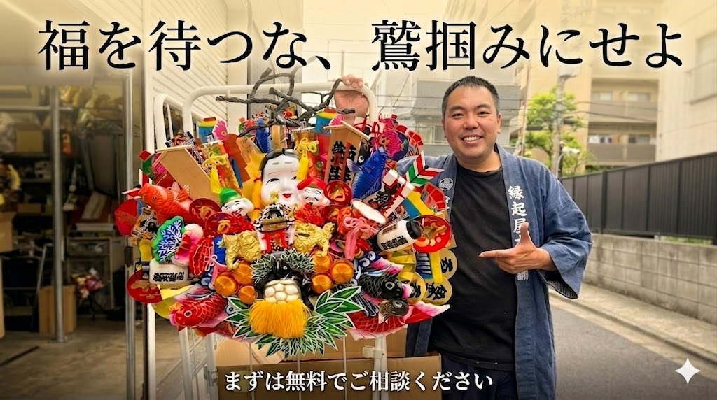 創業80年の看板「縁起屋本舗」の半纏を羽織り、メガネを外した自信に満ちた笑顔の職人が、オーダーメイドの熊手飾りを指差して無料相談を呼びかけるCTA画像。